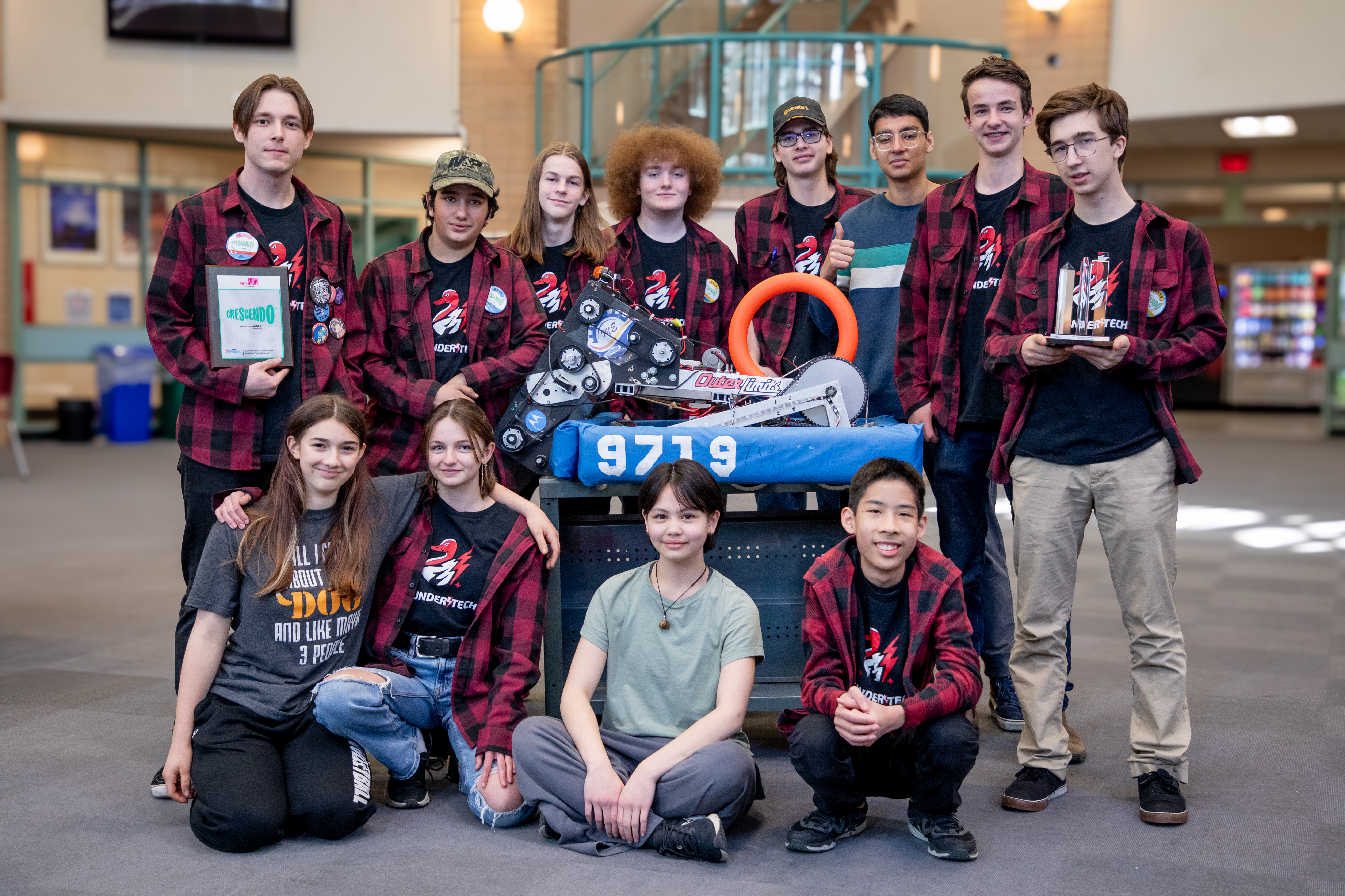 Members of the ThunderTech Robotics team pose with their robot, Cobra Chicken, at Thomas Haney Secondary.